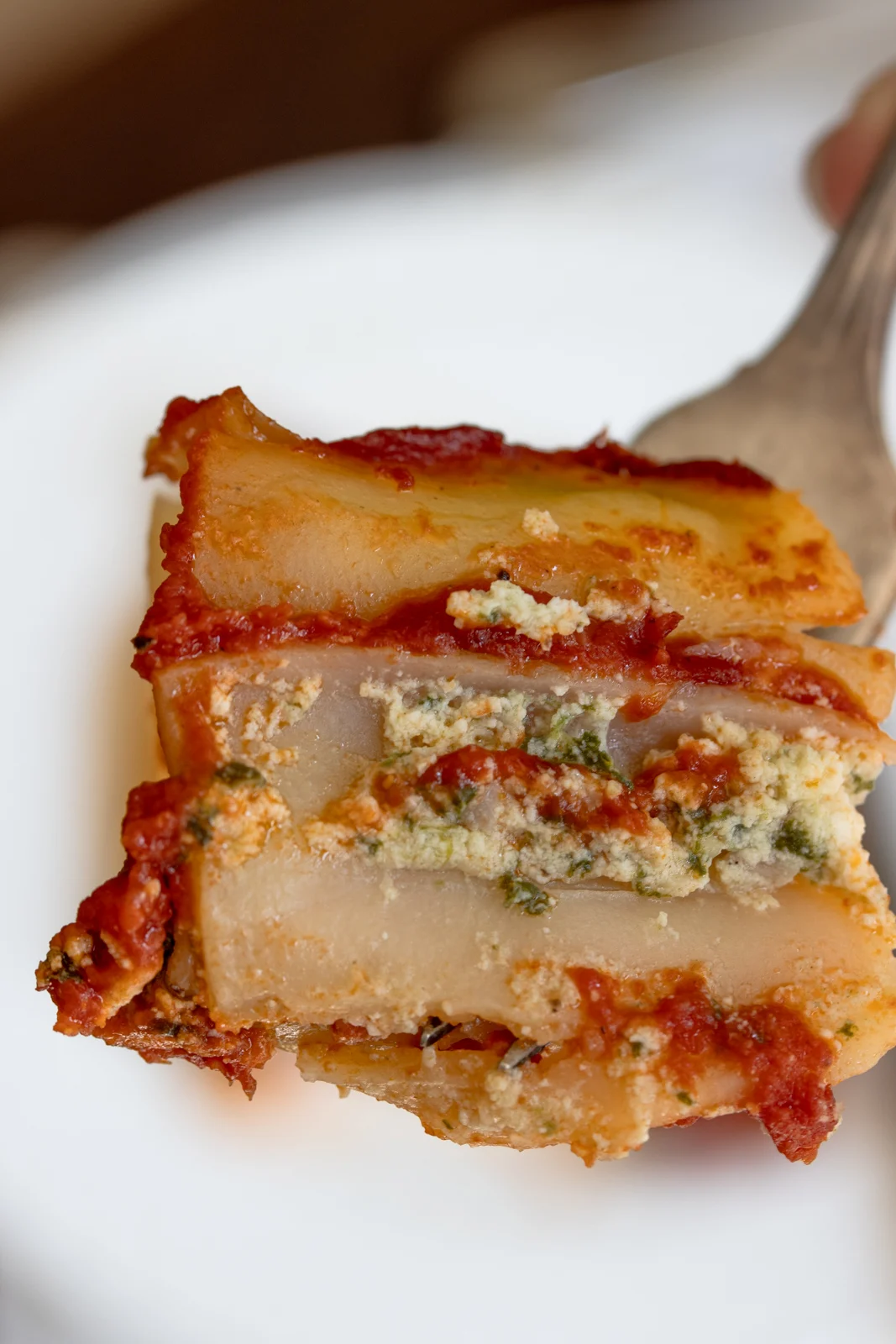 A piece of stuffed cannelloni on a fork.