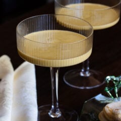 Zabaglione served in a couple glass with savoiardi cookies next to them.