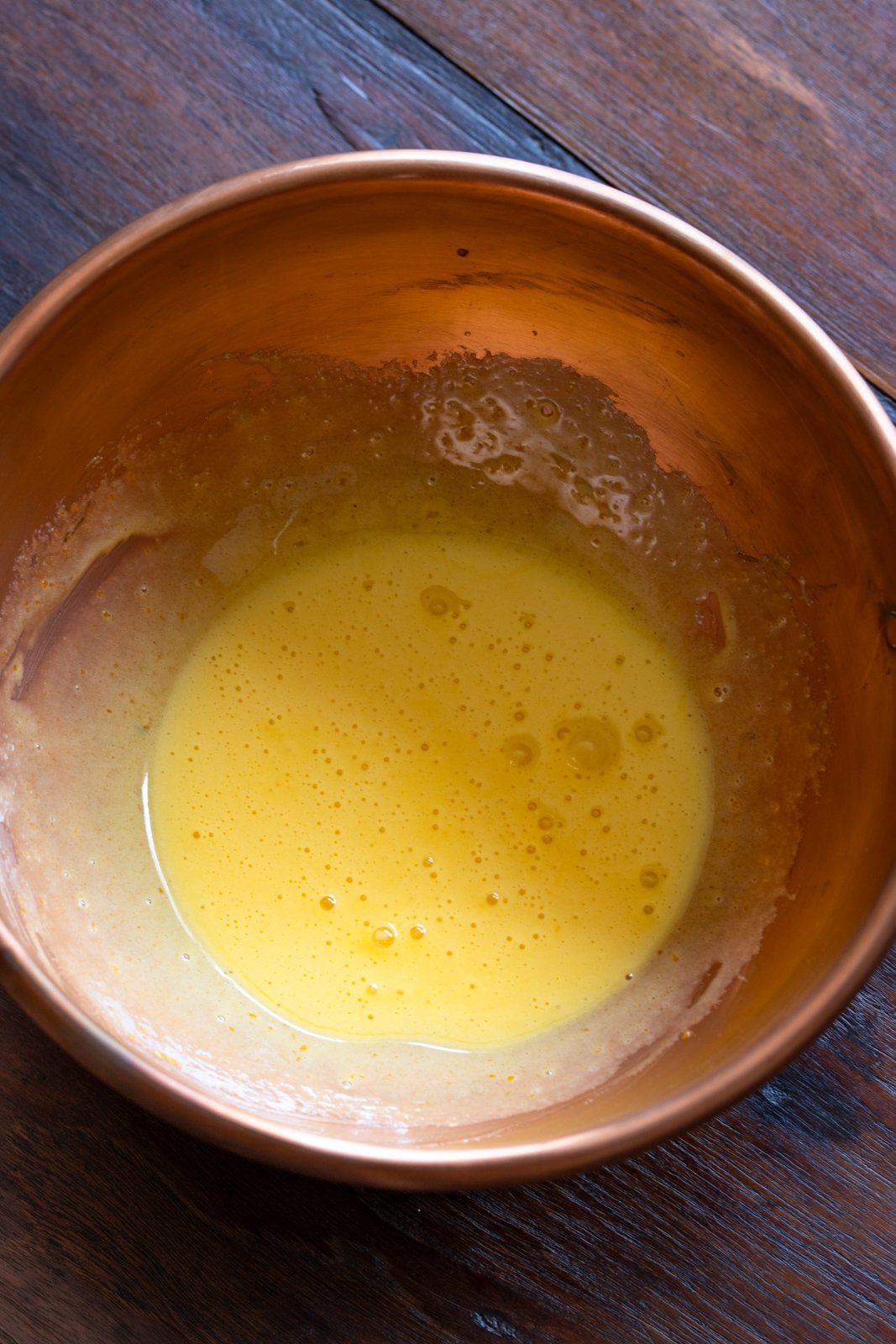 Egg yolks beaten with sugar in a copper bowl.