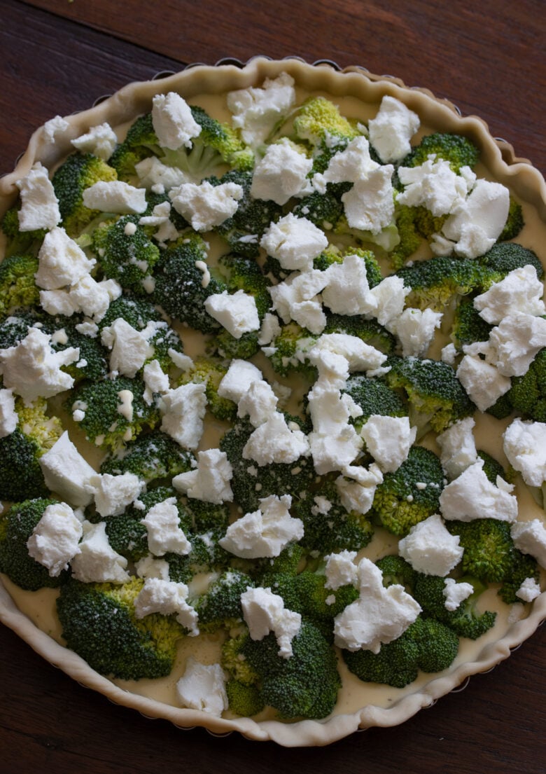 Goat cheese placed atop the broccoli florets and the egg mixture.