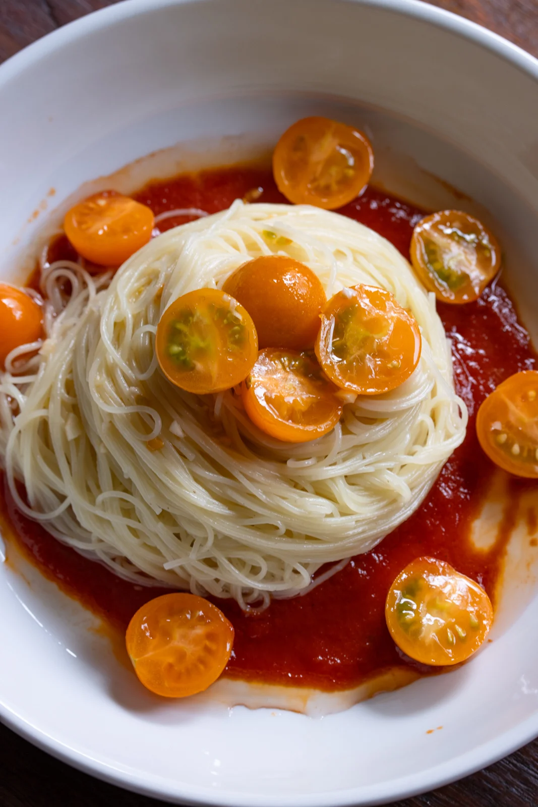 Cherry tomato pasta served in a white bowl.