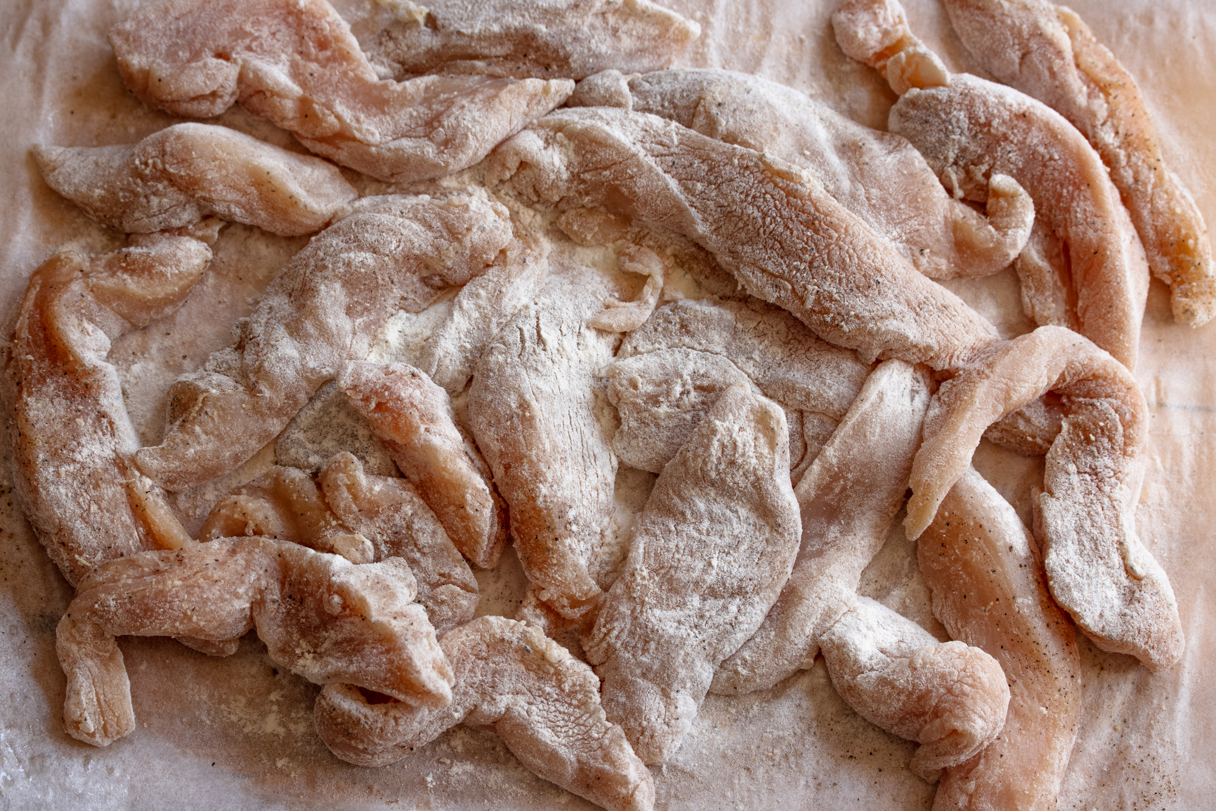 Chicken strips dredged in flour.