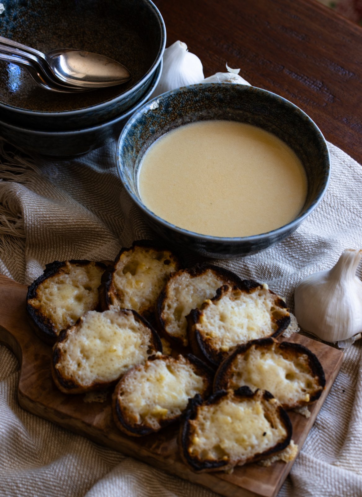 Garlic soup served in blue bowls with cheese croutons by its side. 