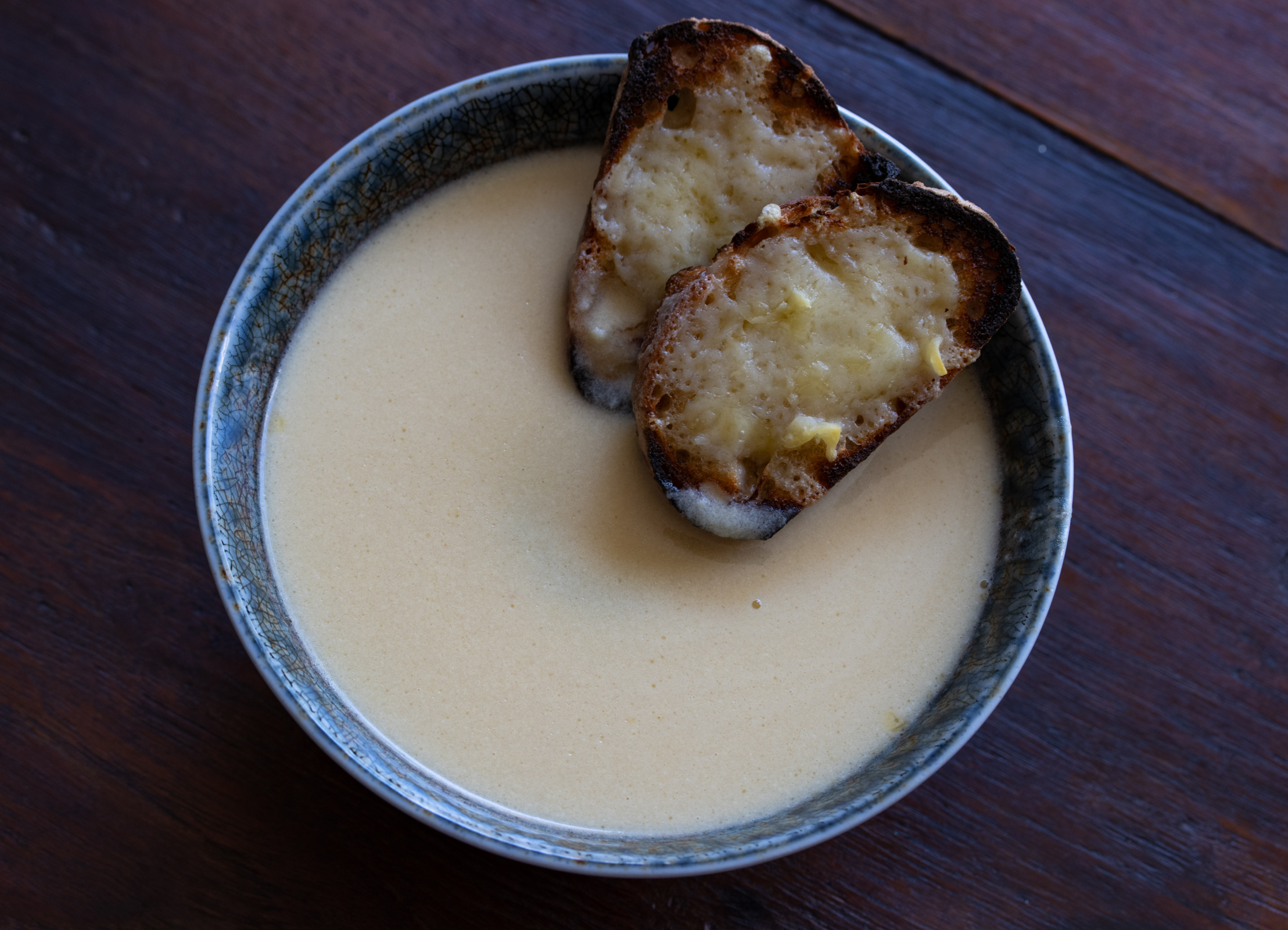 Cheese croutons placed in teh garlic soup bowl.