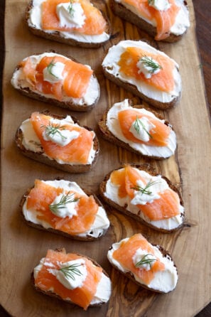 Smoked salmon appetizers on a serving cutting board.