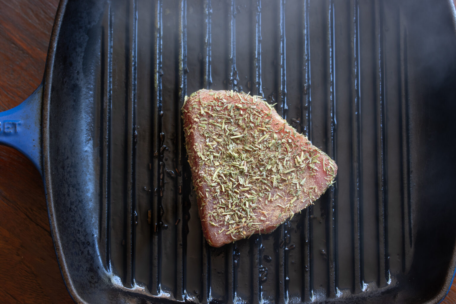 Tuna steak placed on a hot grill pan for one minute on each side.