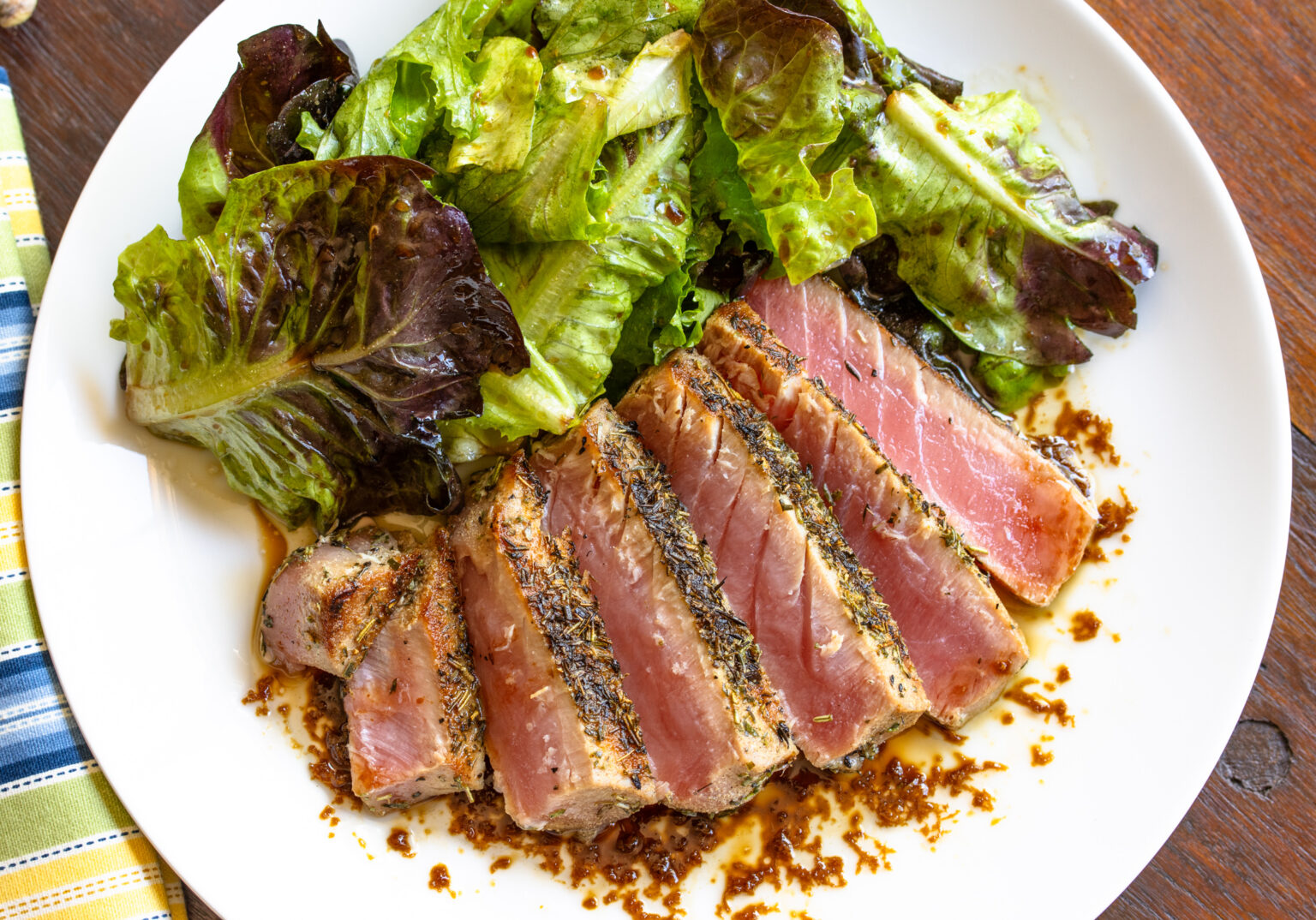 Tuna steak fanned out on a white plate.