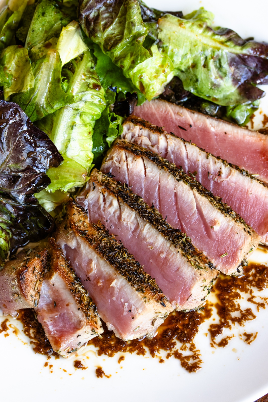 Sliced tuna steak served with salad.