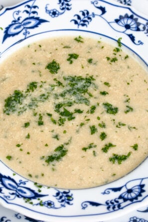 Stracciatella soup served in a white and blue pattern soup dish.