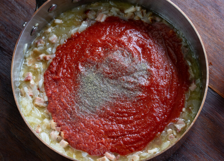 Tomato sauce, wine and black pepper added to the cooked onion mixture.