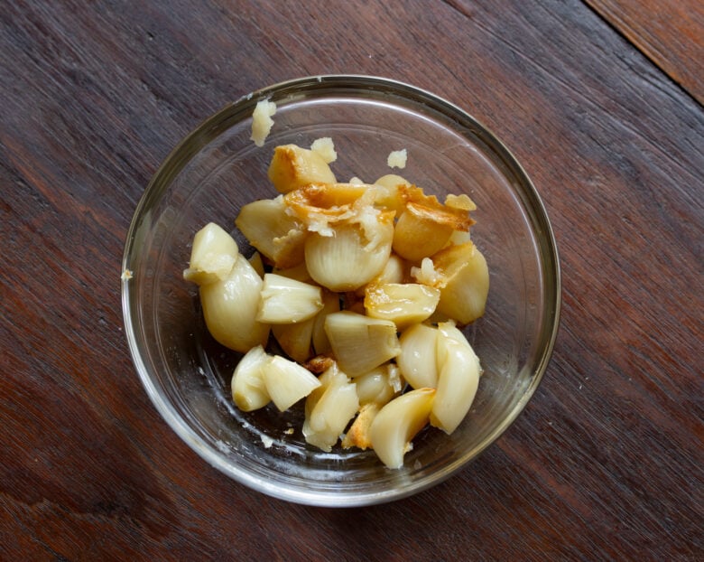 Roasted garlic removed from teh casing and placed in a glass container ready to be used when needed it.