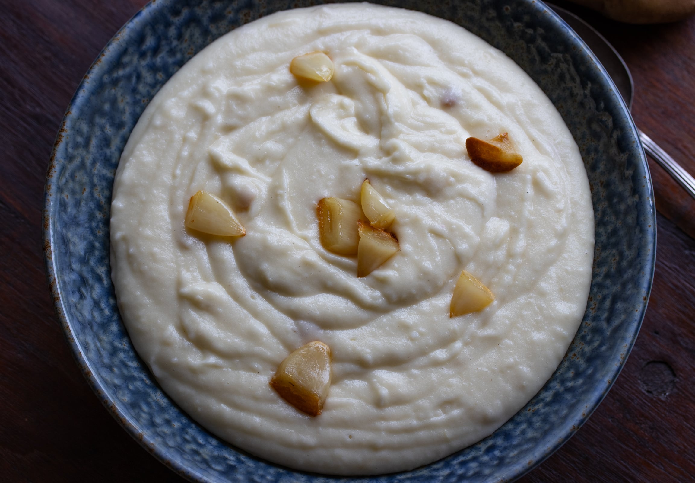 Mashed potatoes all done and served with intact roasting garlic cloves.