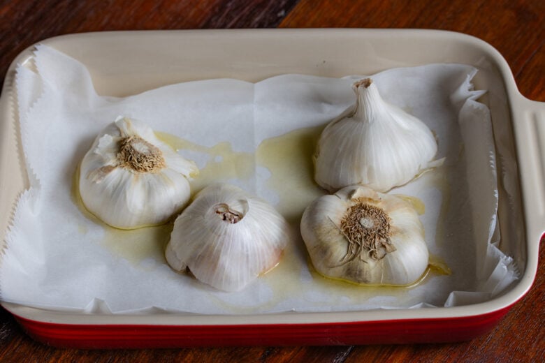 Garlic cut in half and placed facedown on a roasting pan.