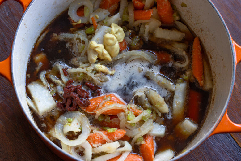 Beer, broth, tomato paste, Dijon mustard have been added to the pan and given a great stir.