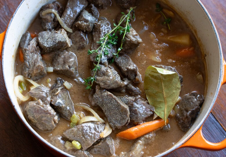 Beef added back to the Dutch oven. Fresh thyme and bay leaf added as well. Ready to be covered and simmered for a couple of hours.