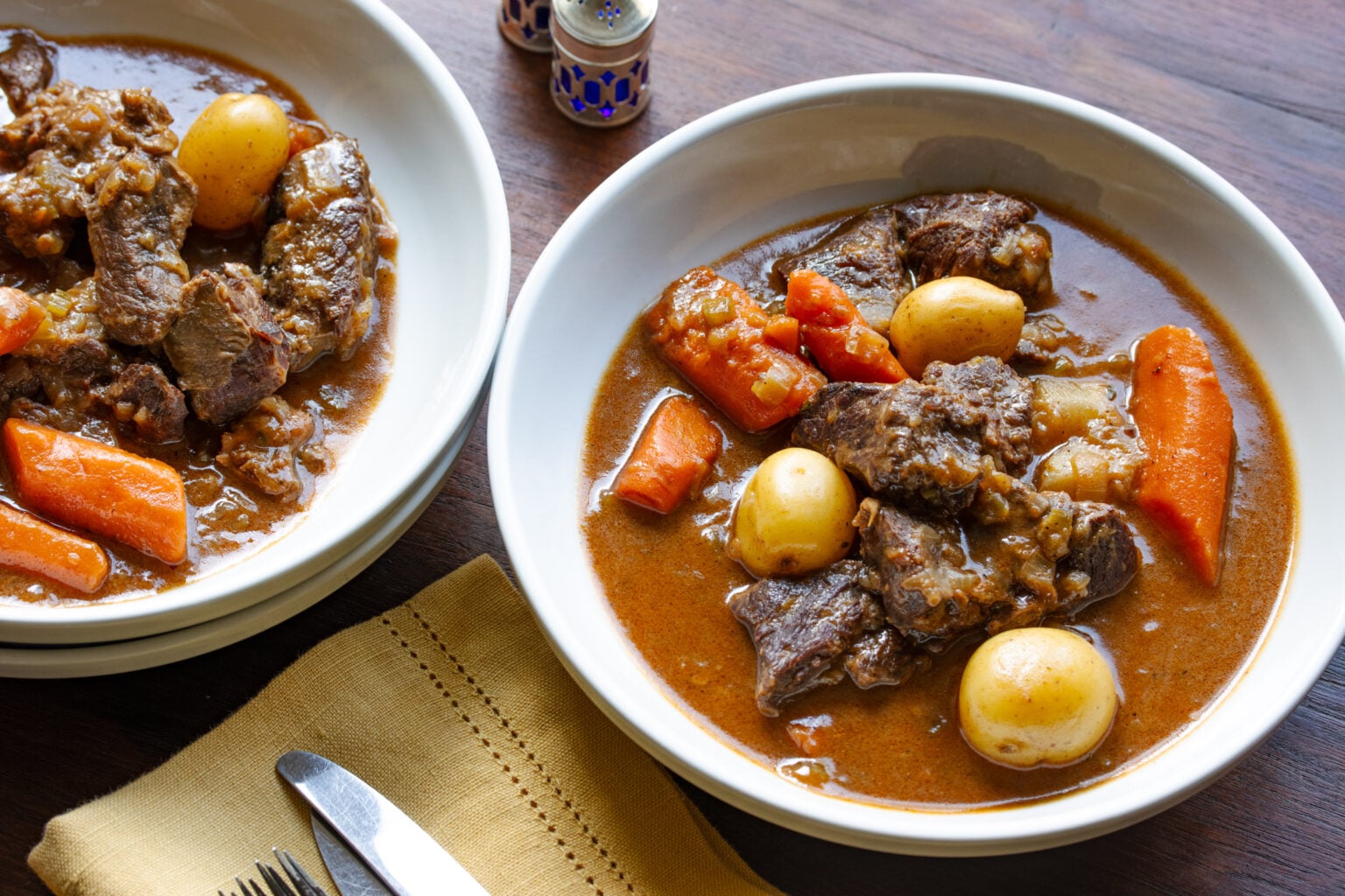 Guinness beef stew served in while large bowl style dishes to hold the juices with the meat. 