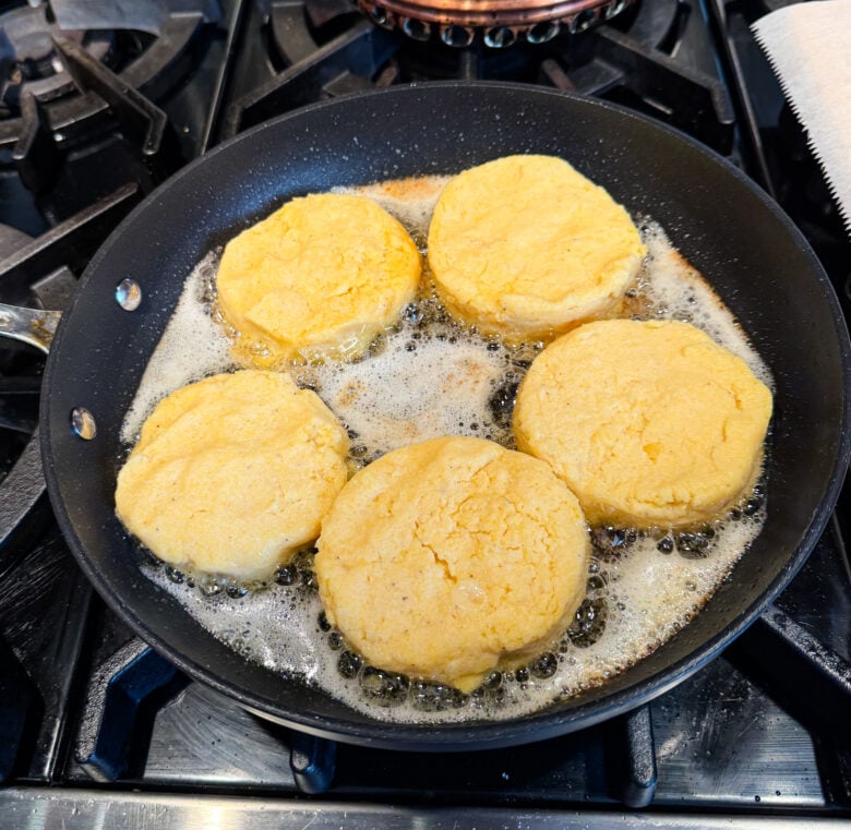 Crispy polenta frying with oil in a skillet.