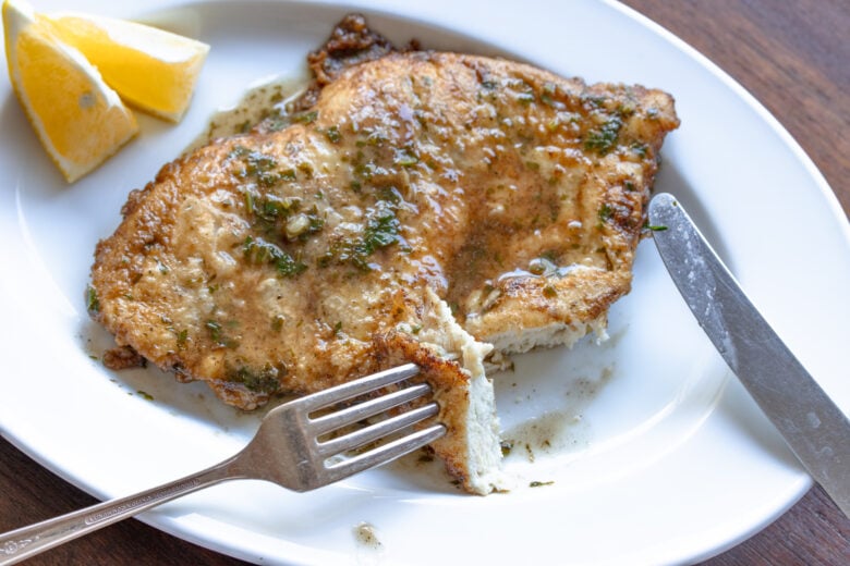 A piece of  chicken sliced and on a fork ready to be enjoyed. 