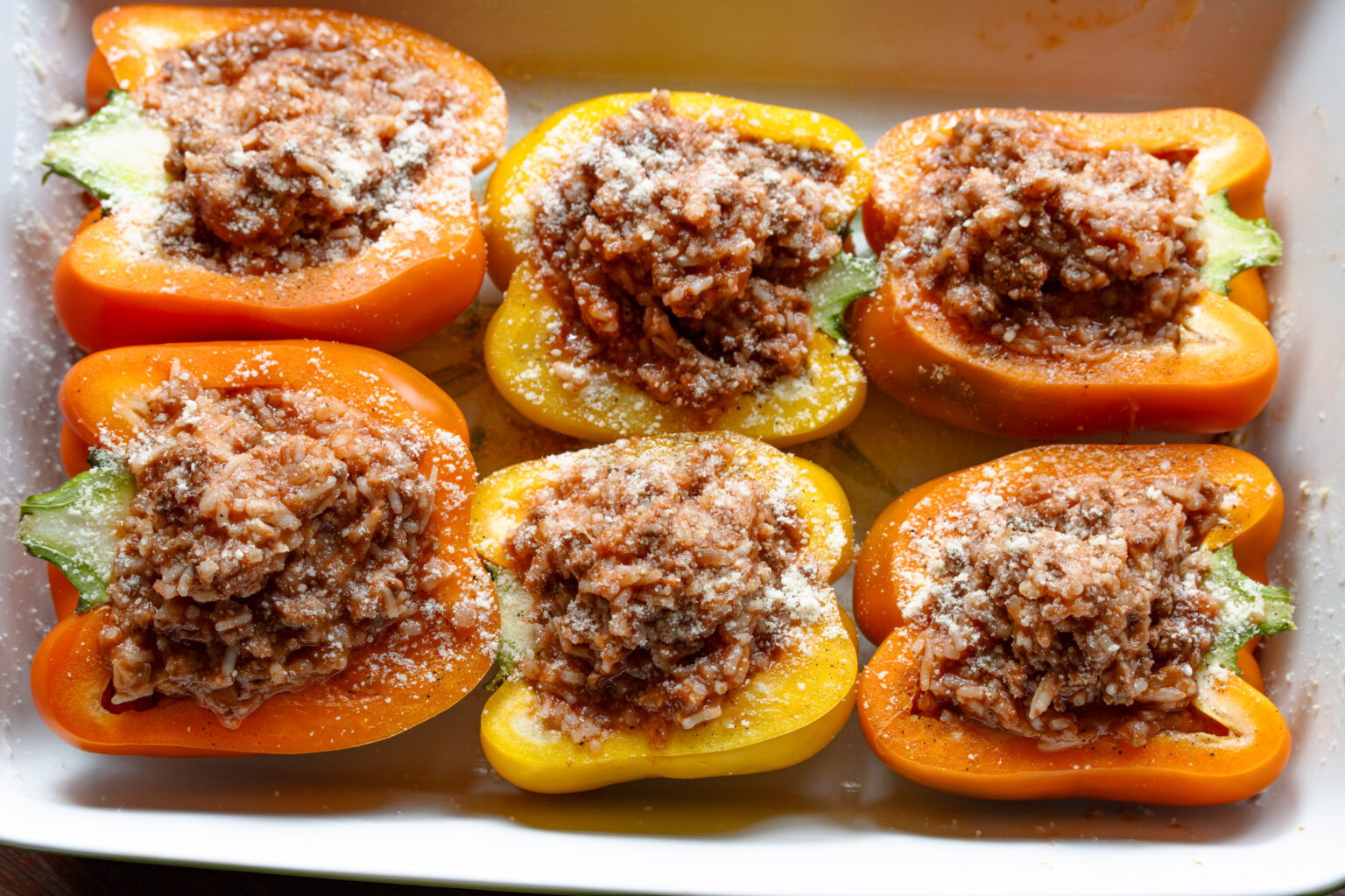 Stuffed bell peppers with ground beef and rice ready to enter the oven.