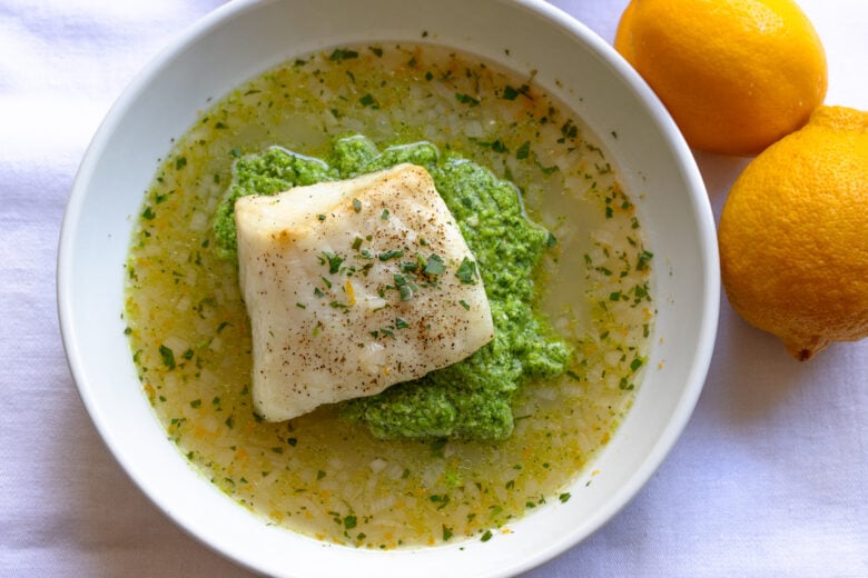 Lemon soup served in white bowls with fresh lemons alongside.