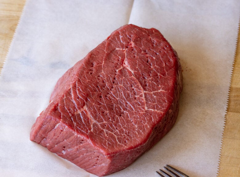 London broil steak poked with a fork.