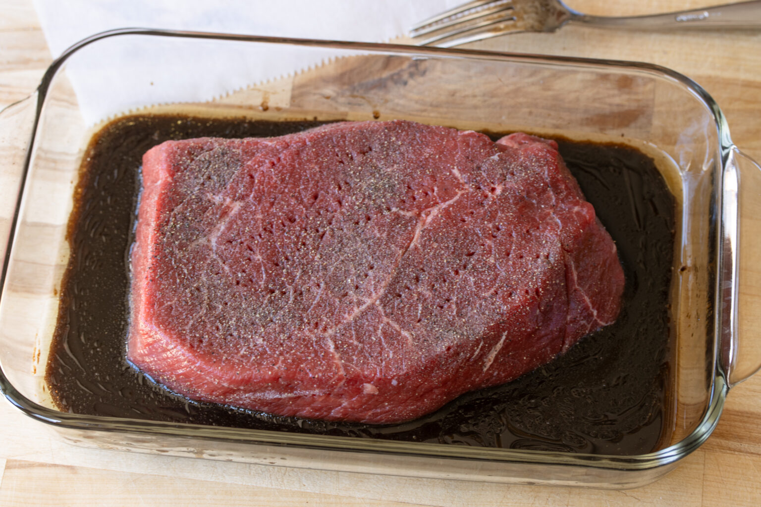 Well seasoned London broil placed in the marinade.