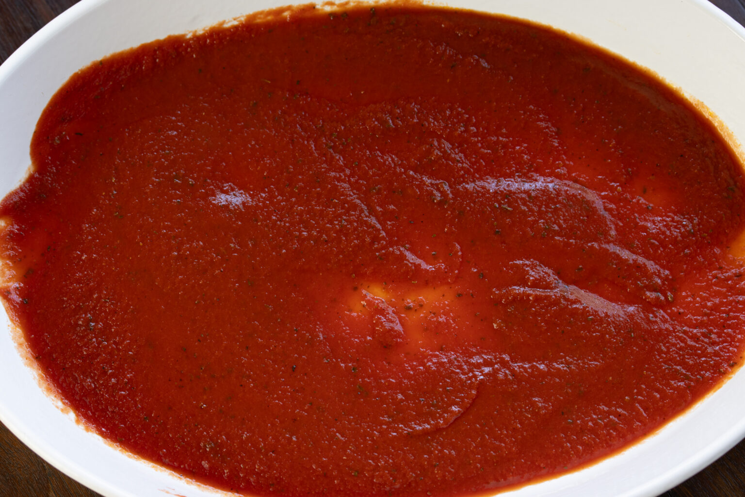 Tomato sauce added to the bottom of the baking dish.
