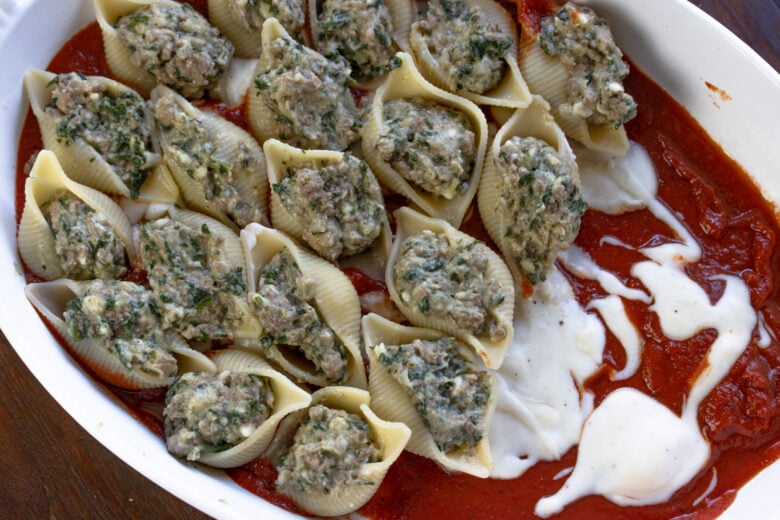 Stuffed pasta shells filled with the ricotta mixture and placed on the baking dish over the tomato sauce. 