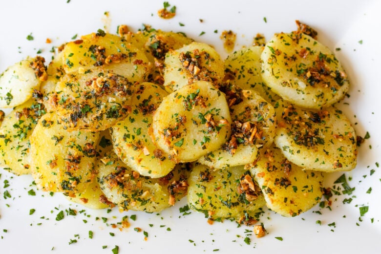 Garlic butter potatoes with parsley served in a white plate. 
