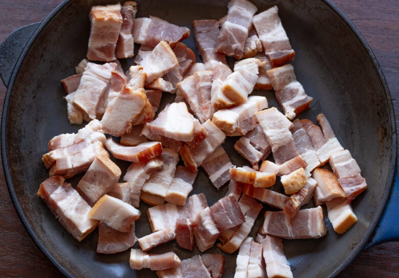 Sliced bacon in a cooking skillet.