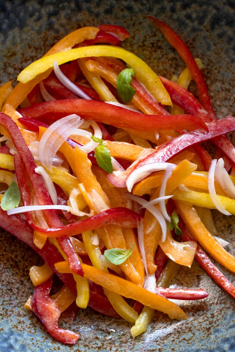 Bell pepper salad served in a brownish blue serving dish.
