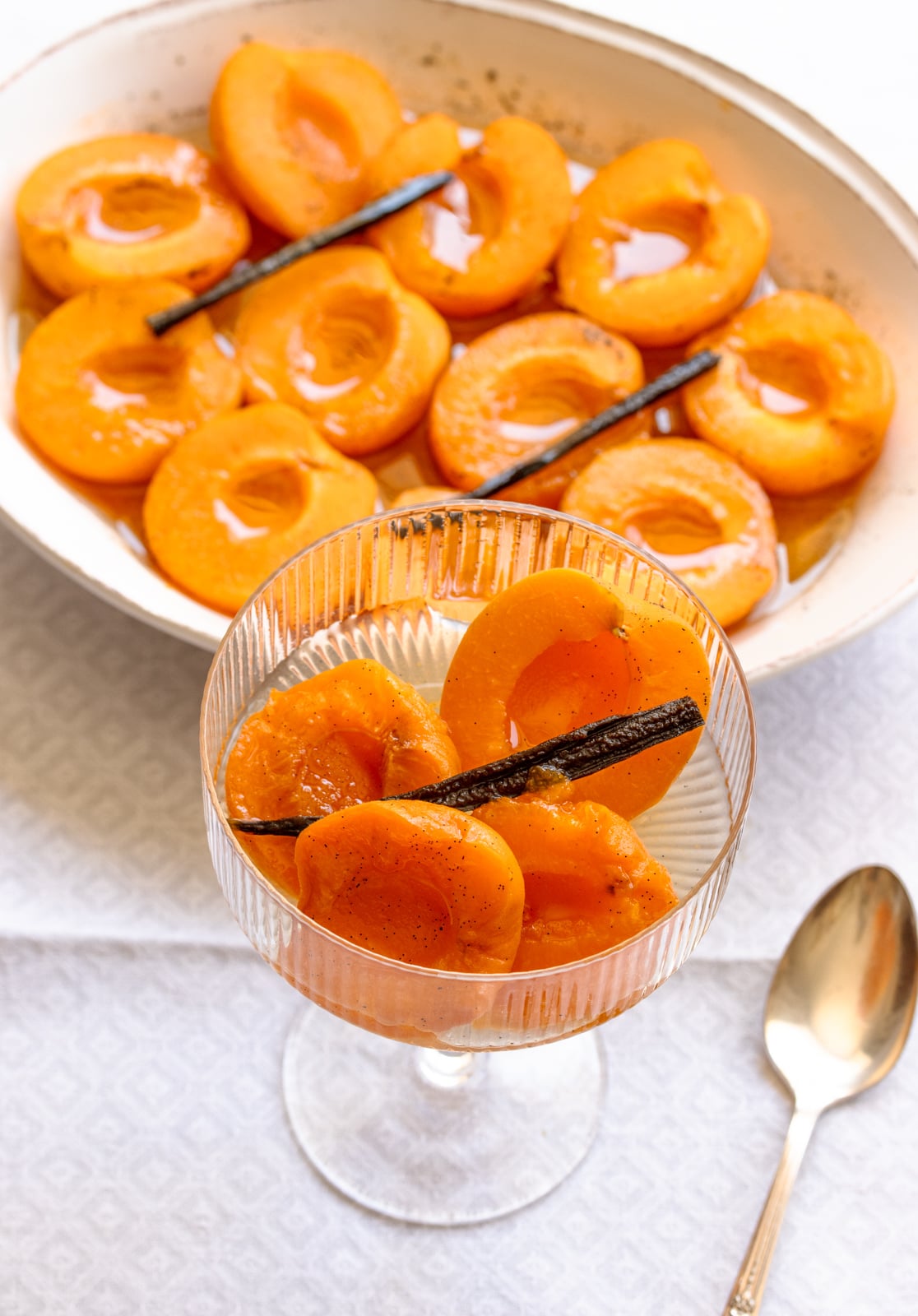 Honey vanilla poached apricots served in a tall glass.