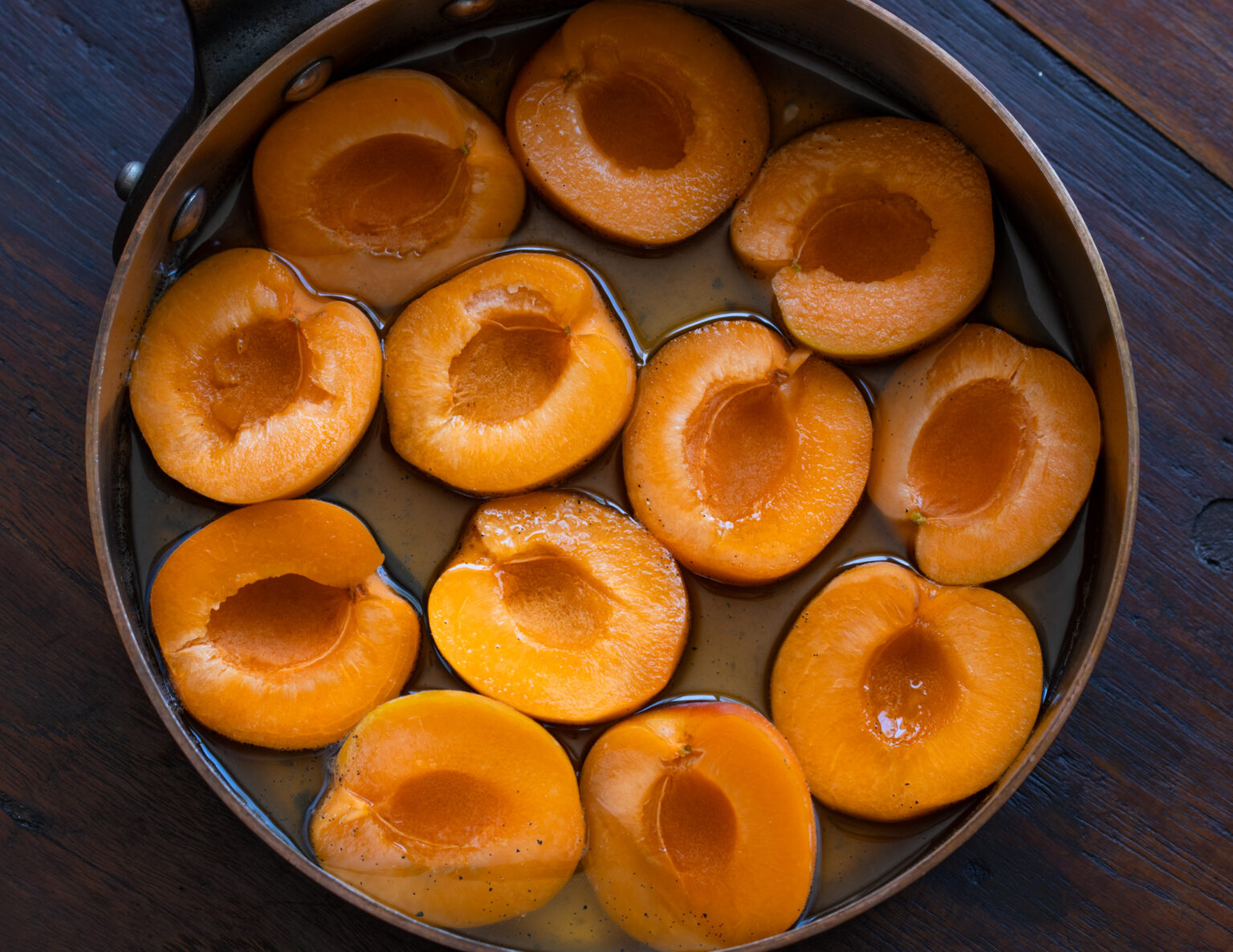 Apricots placed into saucepan to cook with the syrup and soften.