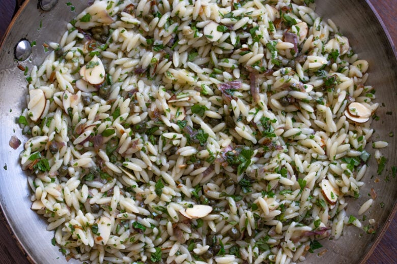Orzo pasta added with the basil, parsley and half of the alsond slices, to the skillet.