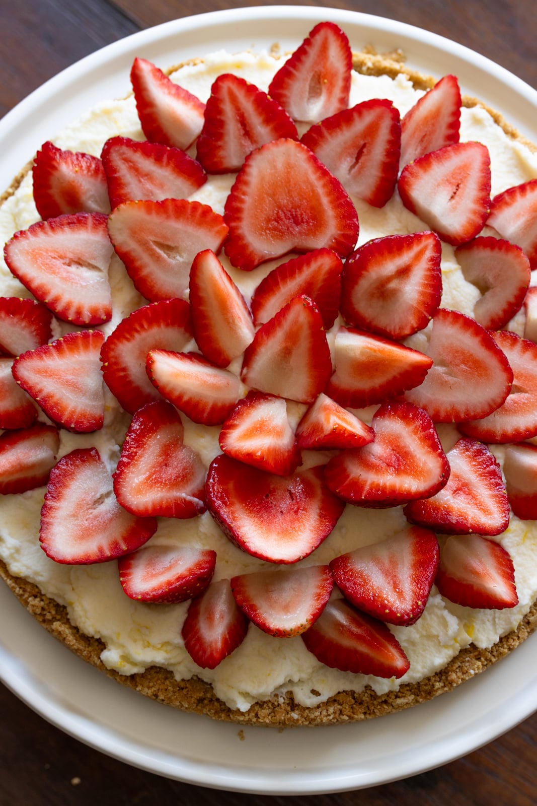Strawberries arranged in a circular pattern over the mascarpone whipped cream mixture. 