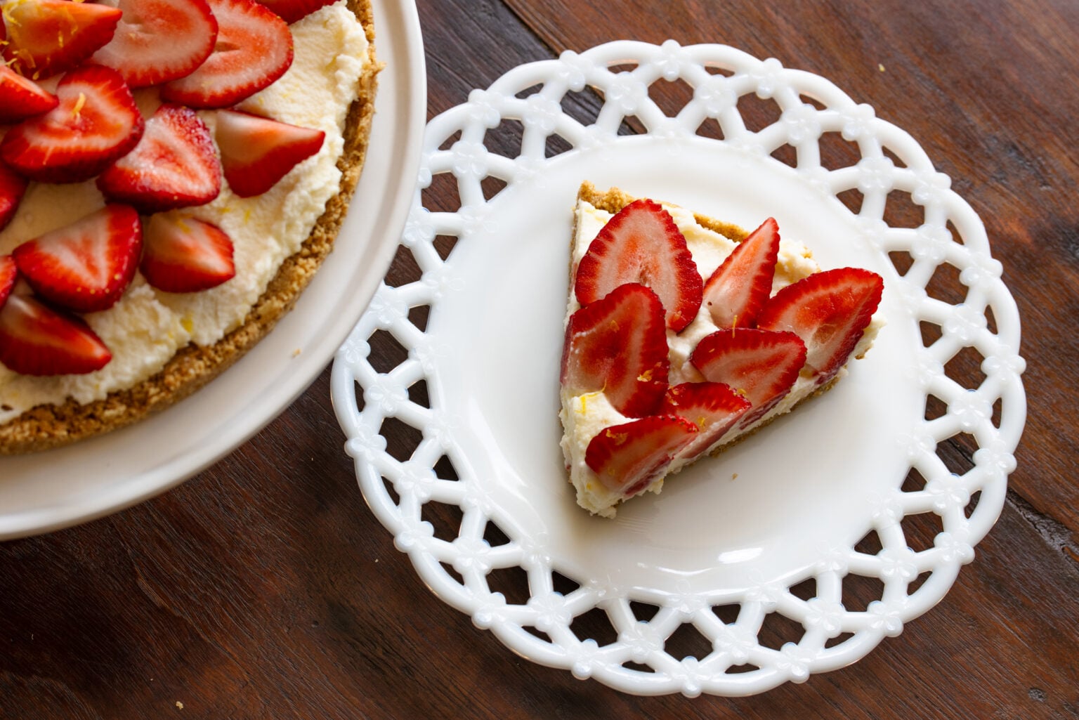 Single slice of strawberry icebox cake served in a while lattice milk glassware plate. 