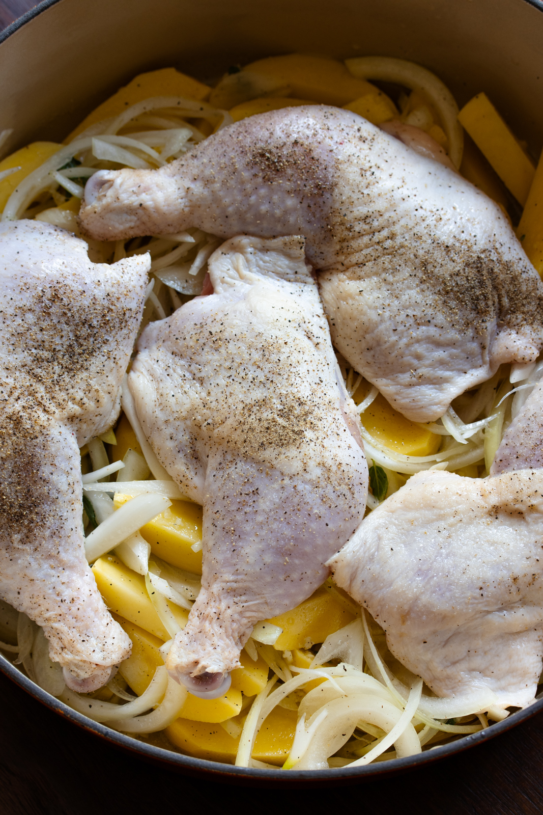 Leg quarter well seasoned with salt and pepper and placed over the potatoes in a Dutch oven.