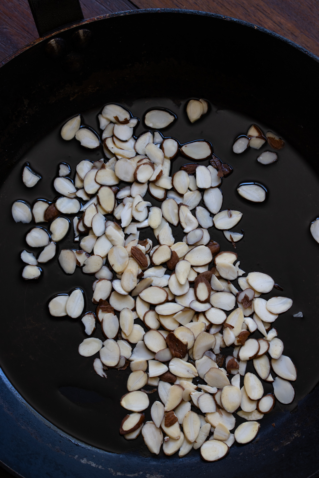 Almond slivers in a skillet with olive oil to be lightly toasted.