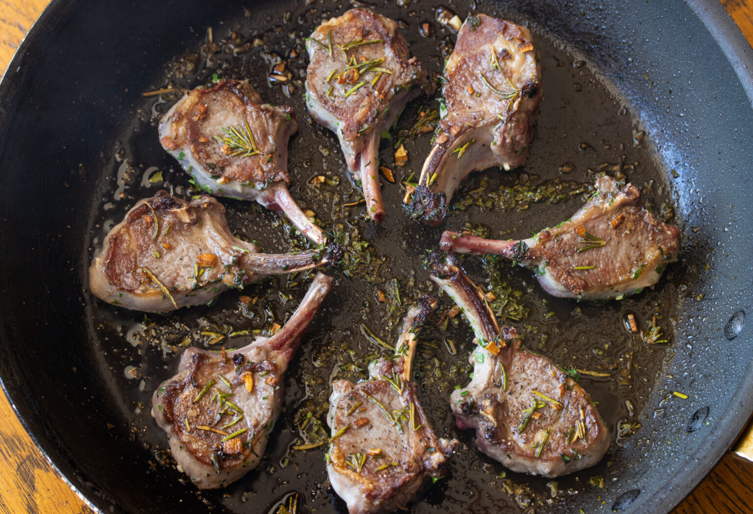 Grilled lamb chops fully cooked in a large skillet. 