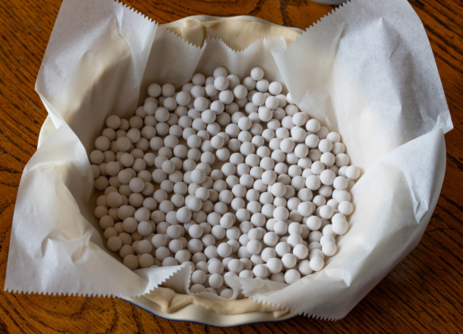 Parchment papaer placed over the pie dough and covered with pie weights.