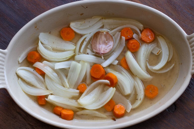 Adding white wine to the onion and carrots and reducing the sauce. 