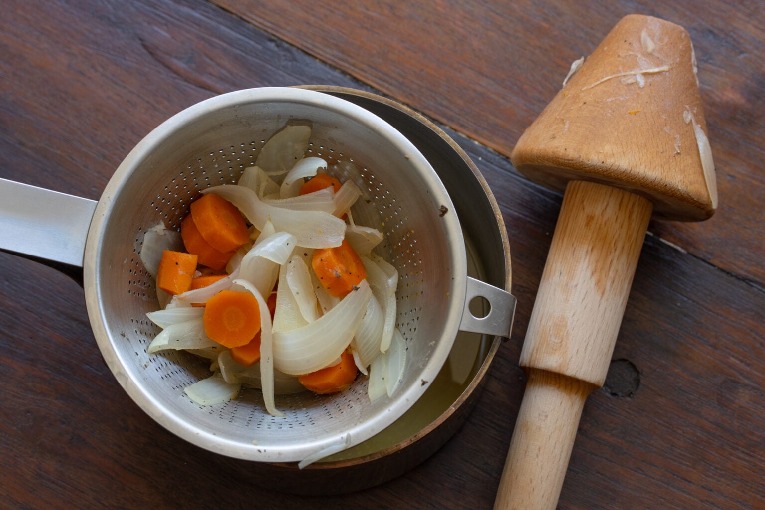 Straining the sauce to collect all the juices.