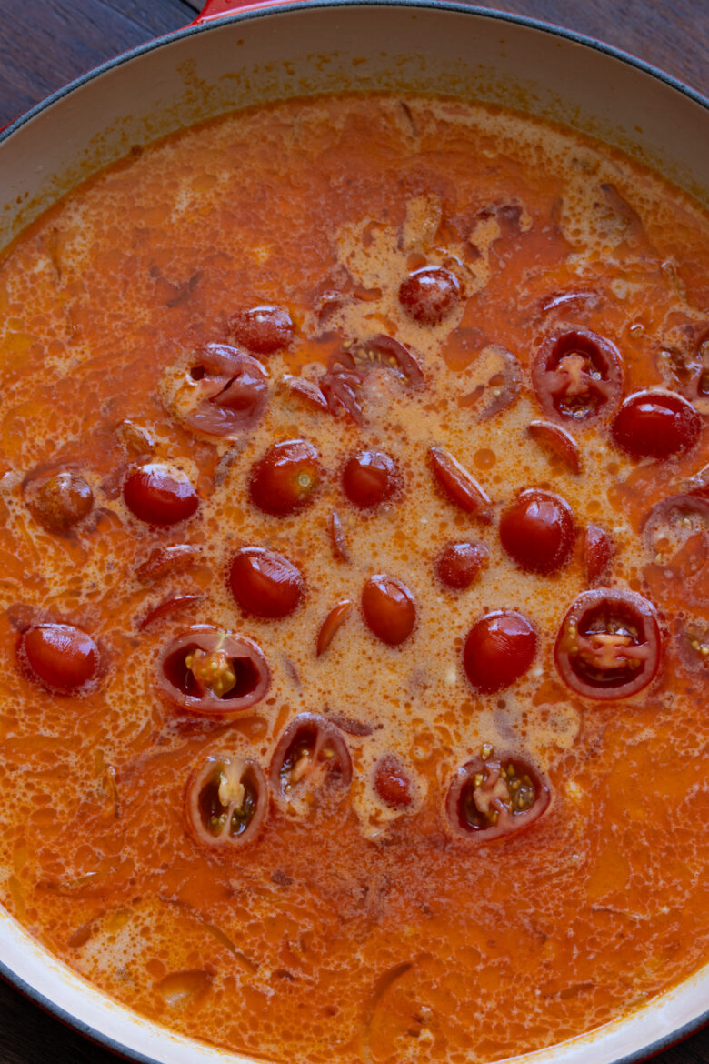 Cut cherry tomatoes and their juices added to the coconut milk.