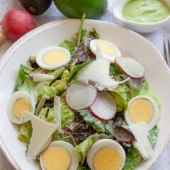 Avocado dressing over mixed green salad.