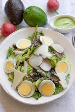 Avocado dressing over mixed green salad.