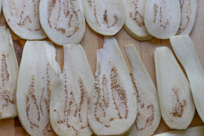 Sliced eggplant stewing with salt to realease all the bitterness.