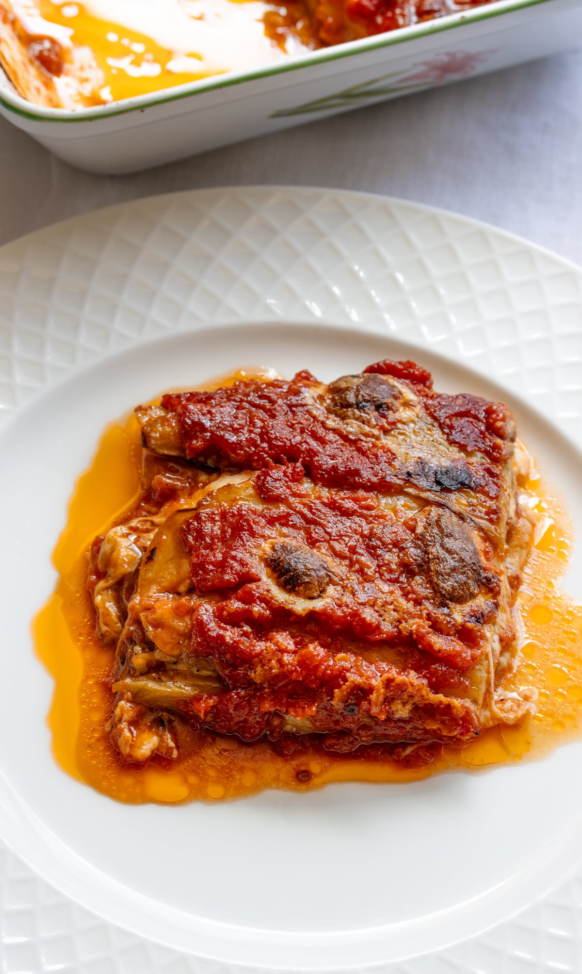 Eggplant parmigiana portion served on a white plate.