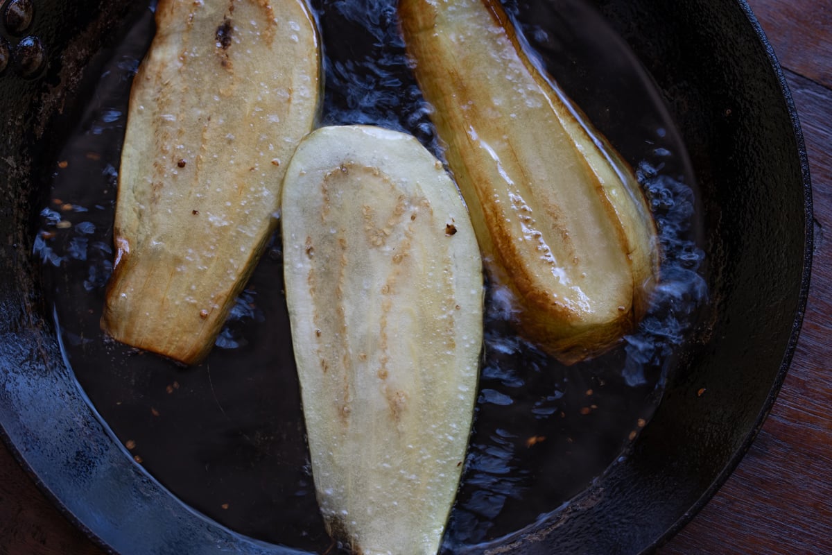 Eggplant slices in frying pan.