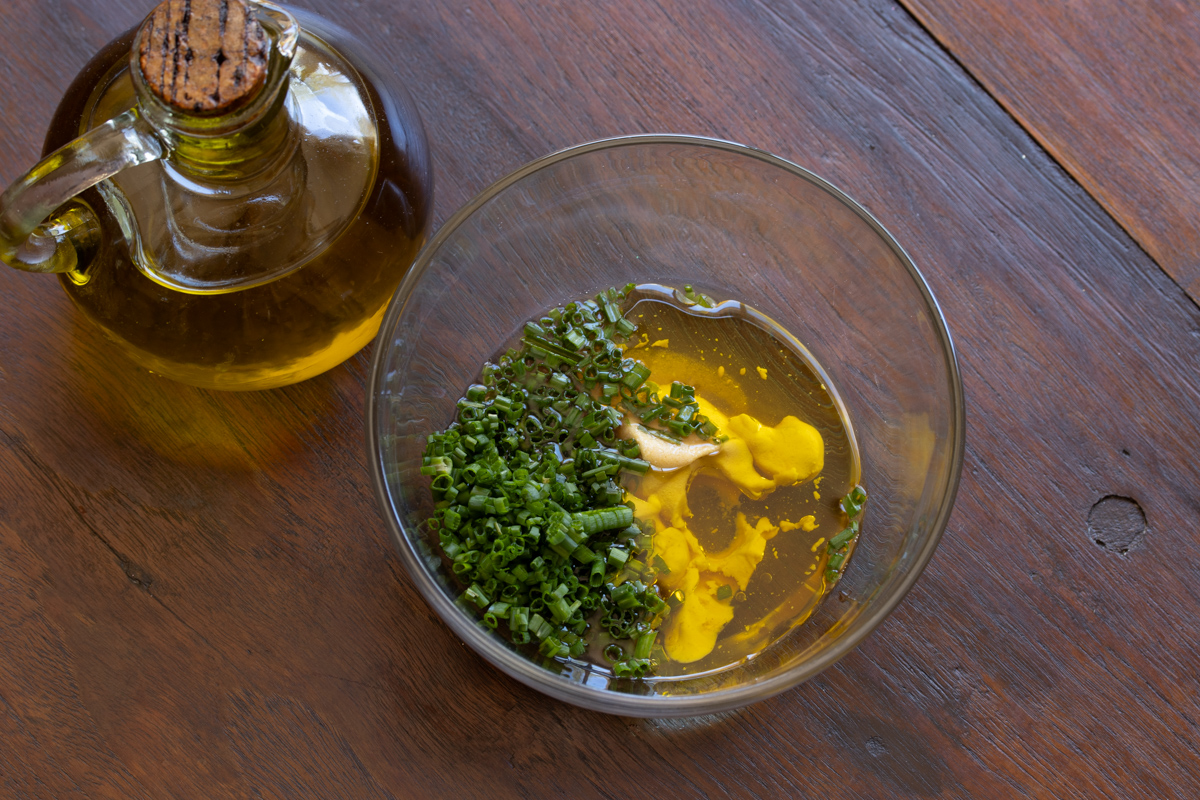 Preparing the vinaigrette with the French mustard, olive oil, vinegar and chopped chives.