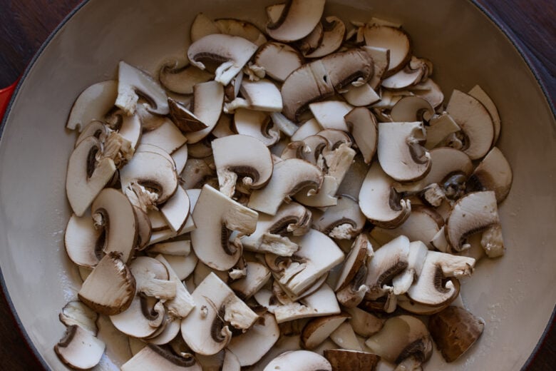 Sliced mushroom placed in the large skillet with the melted butter.
